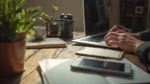 Bureau en bois avec ordinateur portable, plante, tasse et smartphone